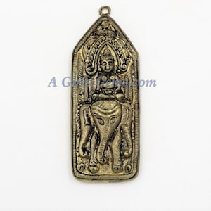 May include: A gold-colored pendant featuring a detailed relief of a deity sitting atop an elephant. The pendant has a loop at the top for attaching a chain.