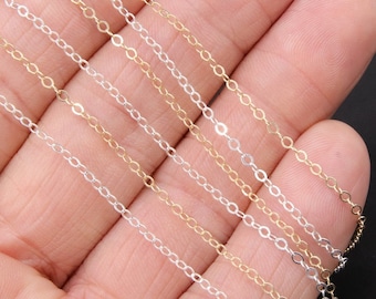 May include: Five different chain styles in silver and gold colors. The chains are laid out on a hand, showing the different lengths and widths.