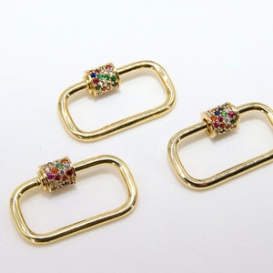 May include: Three gold-toned rectangle-shaped clasps with a colorful jeweled cylinder in the center of each clasp.