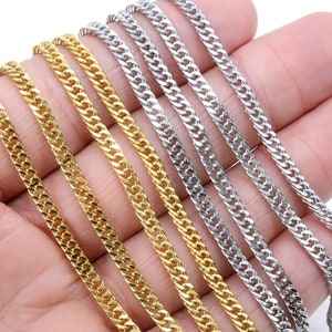May include: A close-up of five gold and silver curb chains. The chains are laid out in a row on a hand, with the gold chains on top of the silver chains.