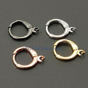 May include: Four earring hoops in different finishes: black, silver, gold, and rose gold. Each hoop has a hinged clasp.