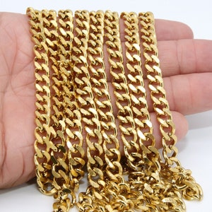 May include: Multiple gold-colored curb chains of varying lengths, laid out on a hand.