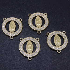 May include: Four gold-toned metal charms featuring a depiction of the Virgin Mary surrounded by clear rhinestones. Each charm has three loops for attaching to jewelry.