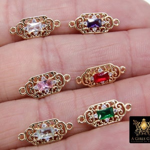 May include: Five gold-tone metal connector charms with different coloured gemstones. Each charm features a decorative filigree design and a rectangular gemstone in the centre. The gemstones are clear, purple, red, pink, and green.