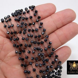May include: A strand of black faceted beads strung on a silver chain. The beads are small and uniform in size. The chain is delicate and has a slightly oxidized finish.
