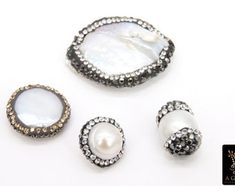 May include: Four white pearl and shell beads with a silver and black rhinestone trim. The beads are round and oval shaped.