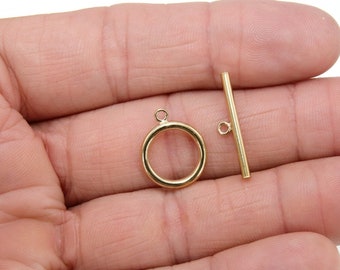 May include: Gold-toned metal toggle clasp with a round ring and a straight bar. The clasp is designed for jewelry making.