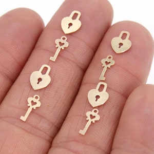 Puede incluir: Una colección de dijes de corazón en forma de candado y llave de color dorado. Los dijes son pequeños y delicados, y son perfectos para agregar un toque de fantasía a las joyas o las manualidades.