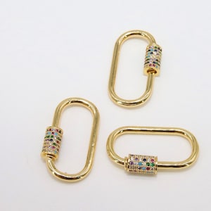 May include: Three gold-toned oval-shaped clasps with a colorful, multi-faceted stone design on the barrel.