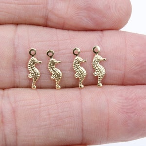 May include: Four gold-colored seahorse charms with a loop at the top for attaching to jewelry or other crafts.