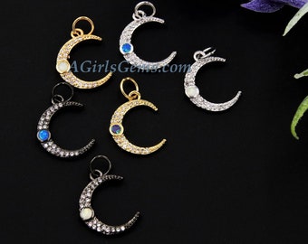 May include: Five crescent moon charms with a single gemstone in the center of each moon. The charms are made of silver, gold, and black metal and are adorned with small clear crystals. The gemstones are blue, white, and iridescent.