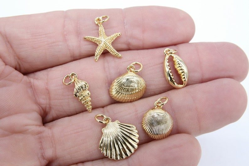 May include: Five gold-tone charms in the shape of seashells and a starfish. The charms have a shiny finish and are perfect for jewellery making.