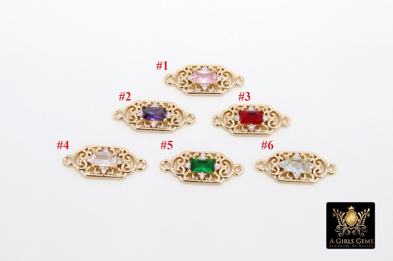 May include: Six gold-tone metal connector charms with different coloured gemstones. Each charm features a filigree design and a rectangular gemstone in the centre. The gemstones are pink, purple, red, clear, green, and light blue.