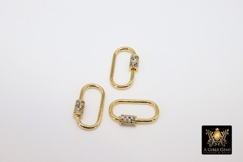 May include: Three gold-toned oval-shaped clasps with a colorful, multi-faceted stone design on the barrel.