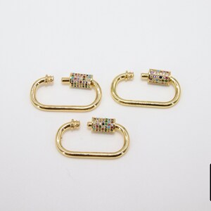 May include: Three gold-toned metal clasps with a colorful, multi-faceted stone design. Each clasp has a D-shaped ring and a cylindrical connector with stones.