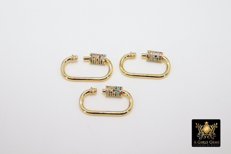 May include: Three gold-toned metal clasps with a colorful, multi-faceted stone design. Each clasp has a D-shaped ring and a cylindrical connector with stones.