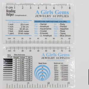 May include: A white plastic ruler with a black and white chart for bead sizes and wire gauges. The ruler also includes a chart of Swarovski birthstone colours and a conversion chart for US standard to metric measurements. The ruler is labelled "A Girls Gems Jewellery Supplies".