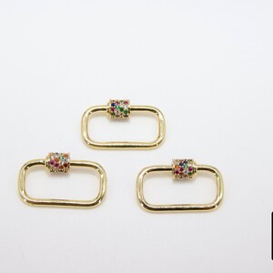 May include: Three gold-toned rectangle-shaped clasps with a colorful jeweled cylinder in the center of each clasp.