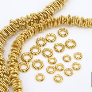 Pu&ograve; includere: Cerchietti per capelli in metallo dorato a forma di spirale. I cerchietti per capelli sono disposti in una pila e in due fili. I cerchietti per capelli hanno un diametro di circa 2,5 cm.