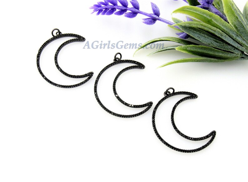 Pu&ograve; includere: Tre ciondoli in metallo nero a forma di mezzaluna con accenti di cristallo nero. I ciondoli misurano circa 3,8 cm di lunghezza.