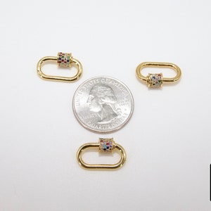 May include: Three gold-toned oval-shaped clasps with a colorful, multi-faceted stone design. Each clasp is approximately the size of a US quarter.