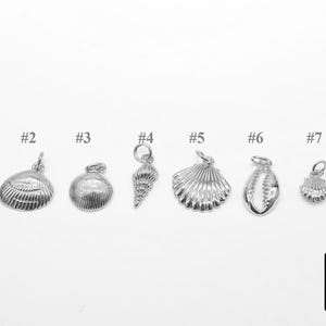 May include: Eight silver charm pendants with different sea-themed designs, including a starfish, seashells, and a conch shell. The charms are numbered 1 through 8.