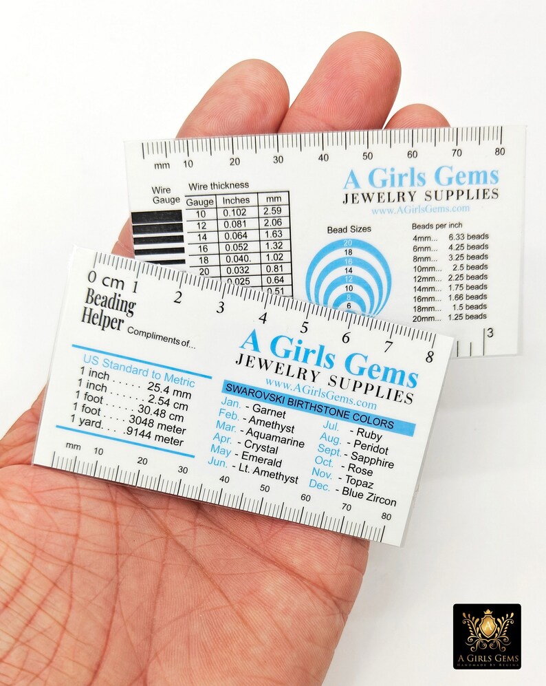 May include: A clear plastic ruler with a white background and black markings. The ruler has a measurement scale in both inches and millimetres. The ruler also includes a chart for wire gauge and thickness, a chart for bead sizes and beads per inch, and a chart for Swarovski birthstone colours.