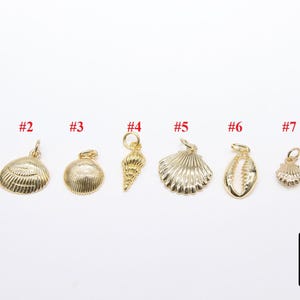 May include: Eight gold-toned charms in the shape of seashells and a starfish. The charms are numbered 1 through 8.
