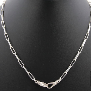 May include: A silver chain necklace with a clasp closure. The chain is made of small, rectangular links.