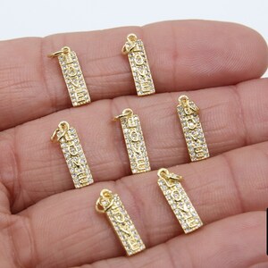 May include: Seven gold-tone charms with clear cubic zirconia stones spelling out the word "LOVE".