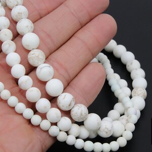 May include: Three strands of white howlite beads, each strand with a different size of round beads. The beads have a natural, marbled look.