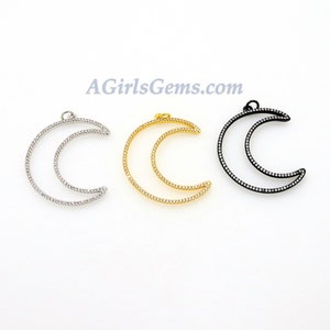 Pu&ograve; includere: Tre ciondoli a forma di mezzaluna con un unico anello in cima per l'appeso. I ciondoli sono in metallo e hanno una finitura argento, oro e nero. Ogni ciondolo &egrave; decorato con piccole pietre trasparenti.