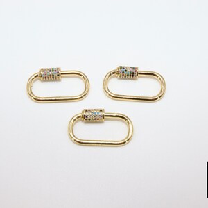 May include: Three gold-toned metal clasps with colorful rhinestones. Each clasp is oval-shaped with a cylindrical section in the center.