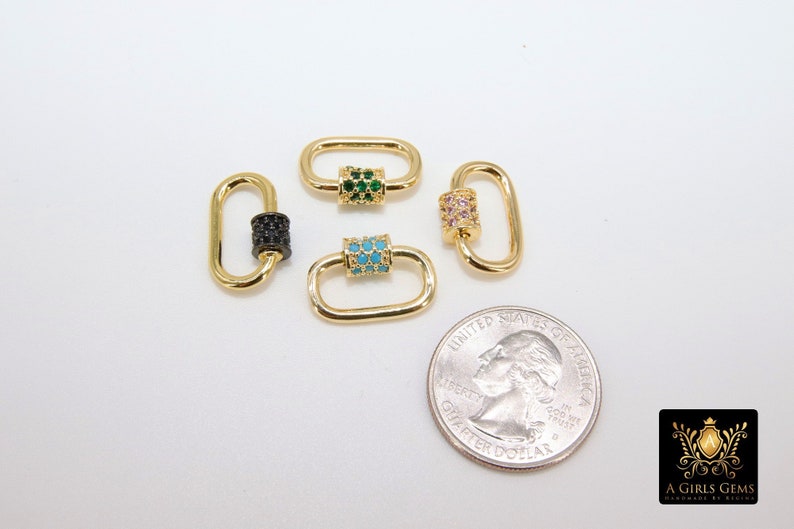 May include: Four gold-colored oval-shaped clasps with decorative center bars. One clasp has a black center, another has green gems, a third has turquoise gems, and the last has pink gems. A quarter is included for size reference.