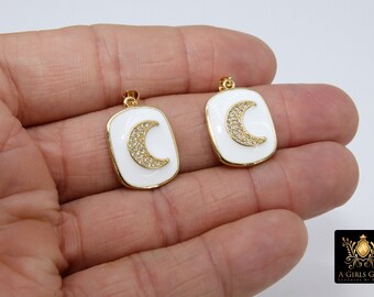 Puede incluir: Dos colgantes de tono dorado con esmalte blanco y un diseño de luna creciente. La luna está incrustada con diamantes de imitación transparentes.