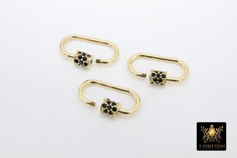 May include: Three gold-colored oval carabiner clasps with black gemstone accents. The clasps are open, showing the screw-on mechanism. The background is plain white. The logo "A Girls Gems" is in the bottom right corner.
