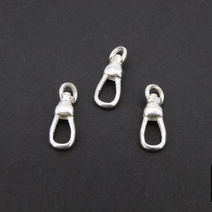 May include: Three silver swivel clasps, each with a rounded top and a small loop at the bottom.