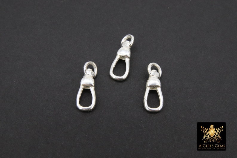 May include: Three silver swivel clasps, each with a rounded top and a small loop at the bottom.