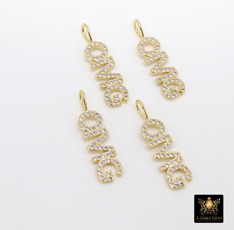 May include: Four gold-tone pendants with the word "OMG" spelled out in clear cubic zirconia stones. Each pendant has a loop at the top for attaching to a chain.