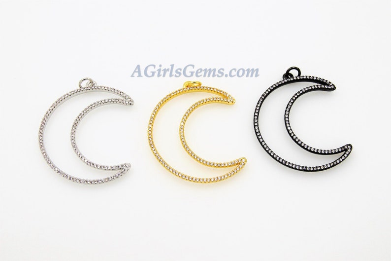 Pu&ograve; includere: Tre ciondoli a forma di mezzaluna con una pav&eacute; di strass trasparenti. I ciondoli sono disponibili in argento, oro e nero.