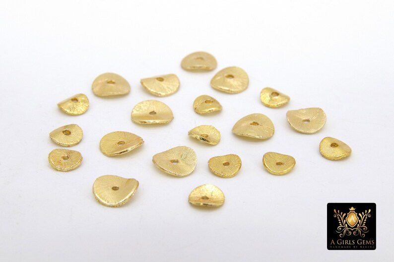 May include: A collection of 18 gold-toned metal beads with a hole in the center. The beads are shaped like a half-circle and have a textured surface.