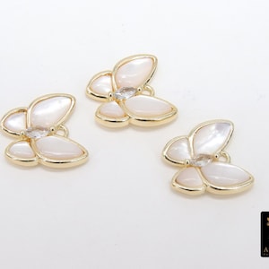 May include: Three gold butterfly charms with white mother of pearl wings and clear rhinestone accents.