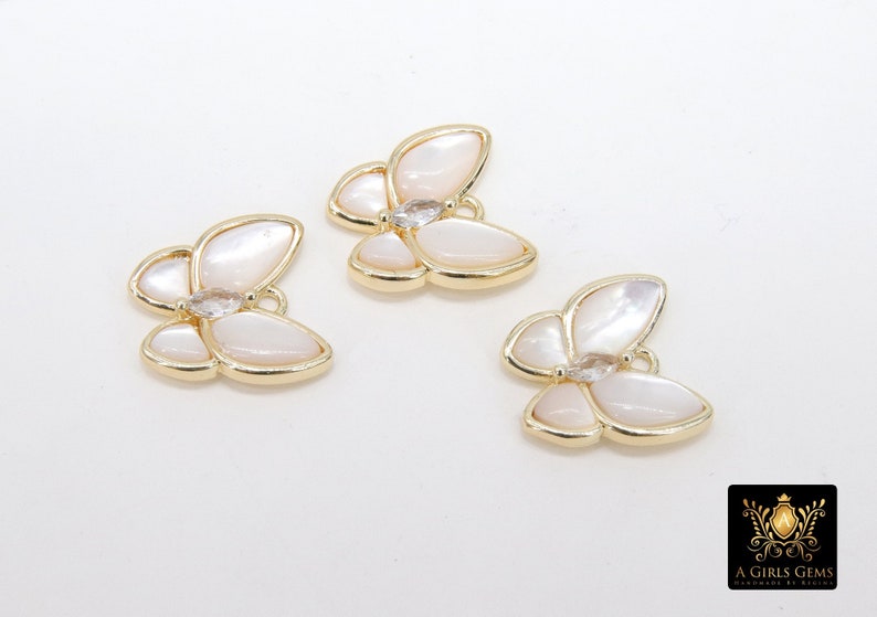 May include: Three gold butterfly charms with white mother of pearl wings and clear rhinestone accents.
