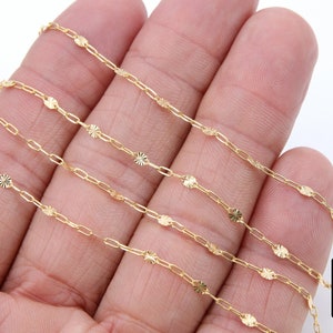 May include: Four strands of gold chain with a delicate, patterned design. Each link features a small, star-shaped embellishment.