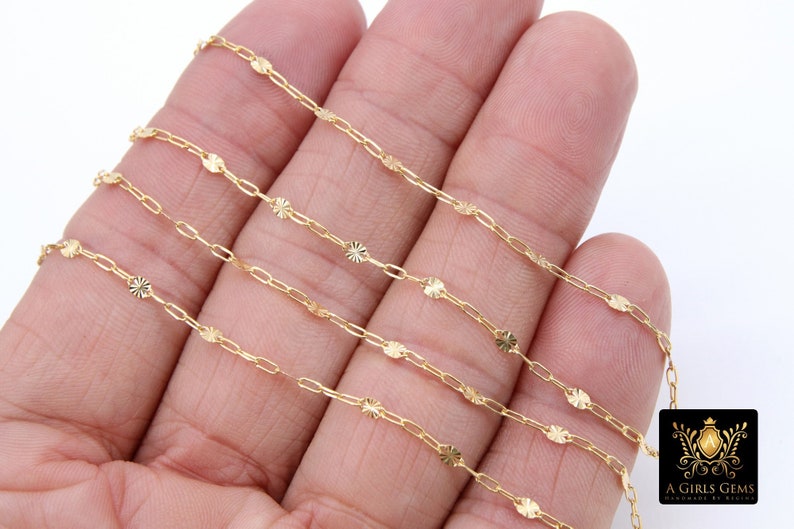 May include: Four strands of gold chain with a delicate, patterned design. Each link features a small, star-shaped embellishment.