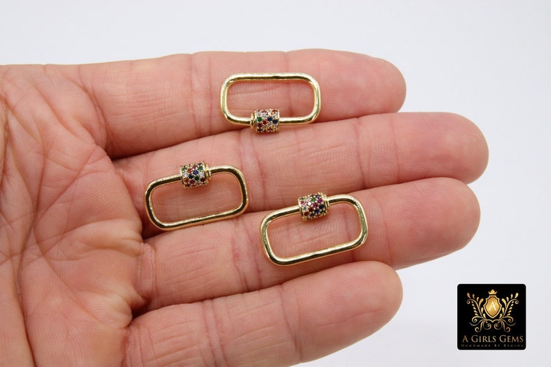 May include: Three gold-toned metal clasps with a colorful, multi-faceted stone design. The clasps are rectangular in shape with a rounded barrel in the center.