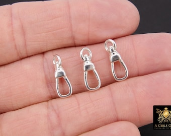 May include: Three silver-toned metal swivel clasps, also known as lobster clasps, are shown on a hand. The clasps are about 1 inch long.