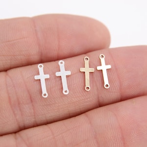 May include: Five small metal cross charms, two silver and three gold, with jump rings for attaching to jewelry.