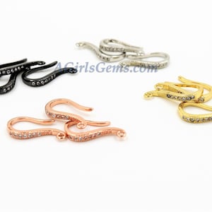 May include: Three pairs of decorative metal hooks with clear crystal accents. The hooks are available in black, rose gold, and gold.