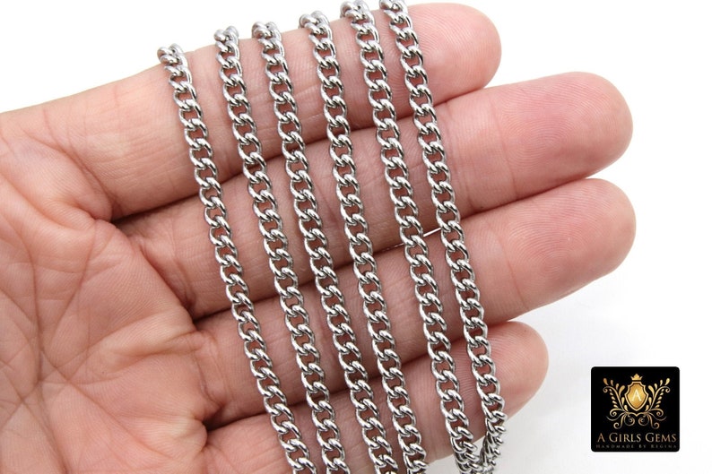 May include: Five silver curb chains of varying lengths, laid out on a hand, showing the different sizes available.